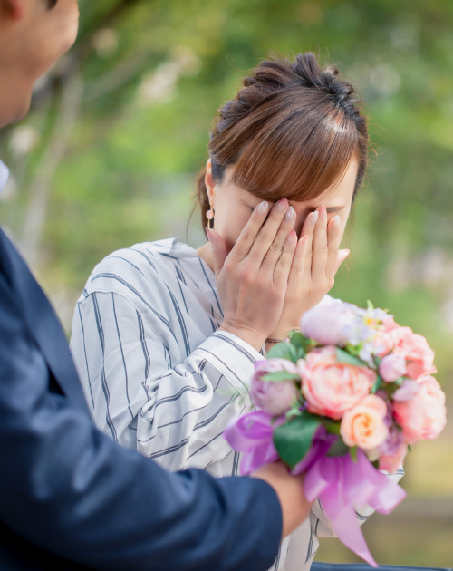 お花をもらってサプライズに感激する女性の写真